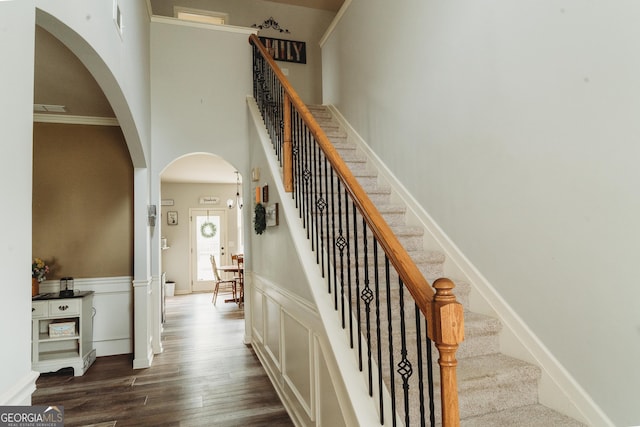 258 Creek View Ln, Acworth, GA 30102 - stairway with arched walkways, wood finished floors, a high ceiling, and wainscoting