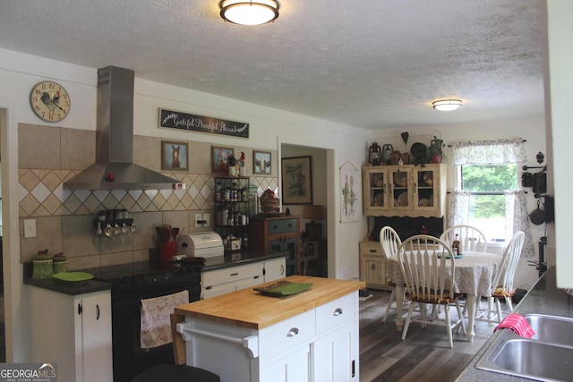 124 Wynn Rd, Mcdonough, GA 30252 - kitchen featuring wall chimney range hood, wood counters, black electric range oven, white cabinetry, and a textured ceiling