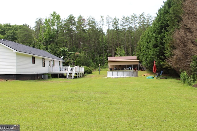 124 Wynn Rd, Mcdonough, GA 30252 - view of grassy yard featuring a deck, an outdoor pool, and central AC