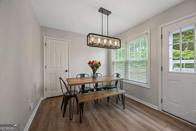 dining area featuring wood finished floors, baseboards, and a chandelier
