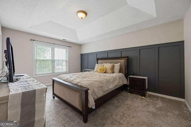 bedroom featuring carpet flooring and a tray ceiling