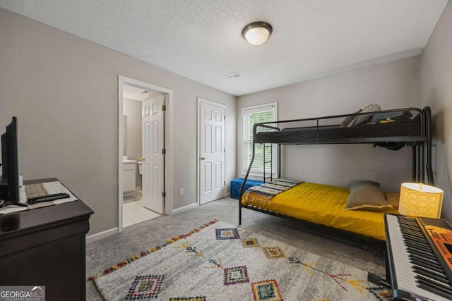 bedroom featuring carpet floors, baseboards, a textured ceiling, and connected bathroom