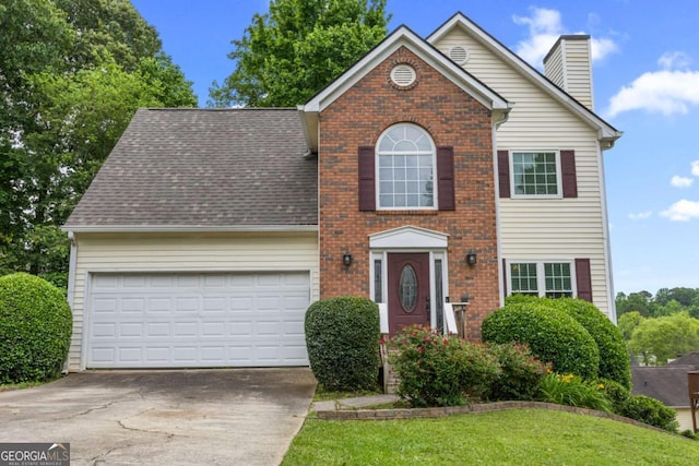 4305 Chesapeake Trce, Acworth, GA 30101 - view of front facade with driveway, an attached garage, a chimney, brick siding, and roof with shingles