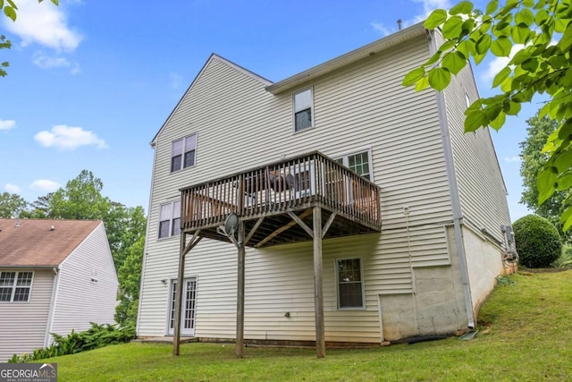 rear view of property with a lawn and a wooden deck