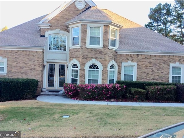 5430 Lemoyne Dr SW, South Fulton, GA 30331 - view of front of house with french doors, brick siding, a front yard, and roof with shingles
