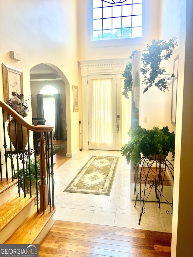 5430 Lemoyne Dr SW, South Fulton, GA 30331 - entryway featuring arched walkways, a high ceiling, wood finished floors, stairway, and baseboards