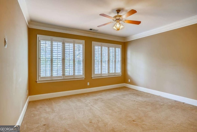 empty room featuring carpet flooring, ornamental molding, baseboards, and ceiling fan