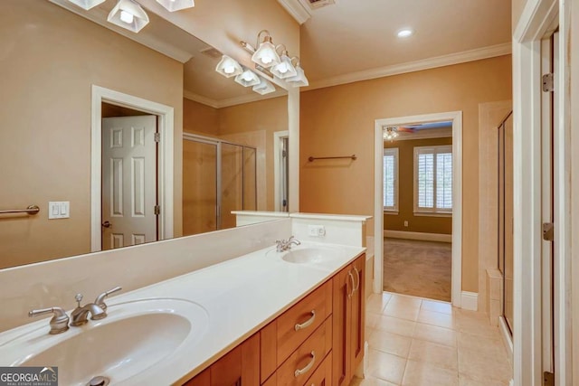 bathroom with tile patterned floors, a shower stall, ornamental molding, double vanity, and baseboards