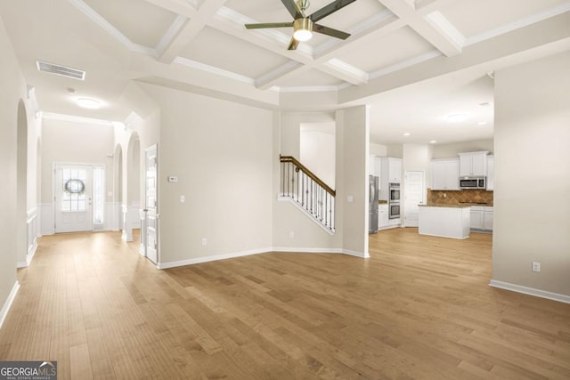 321 Shannon Ct, Mcdonough, GA 30252 - unfurnished living room featuring arched walkways, a ceiling fan, coffered ceiling, light wood-type flooring, and beamed ceiling