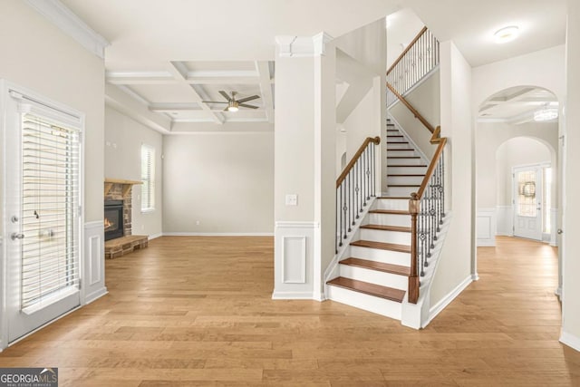 321 Shannon Ct, Mcdonough, GA 30252 - foyer entrance featuring arched walkways, coffered ceiling, a ceiling fan, a fireplace, and light wood finished floors