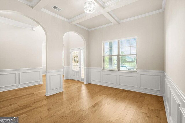 321 Shannon Ct, Mcdonough, GA 30252 - spare room featuring beam ceiling, light wood-style flooring, coffered ceiling, wainscoting, and arched walkways