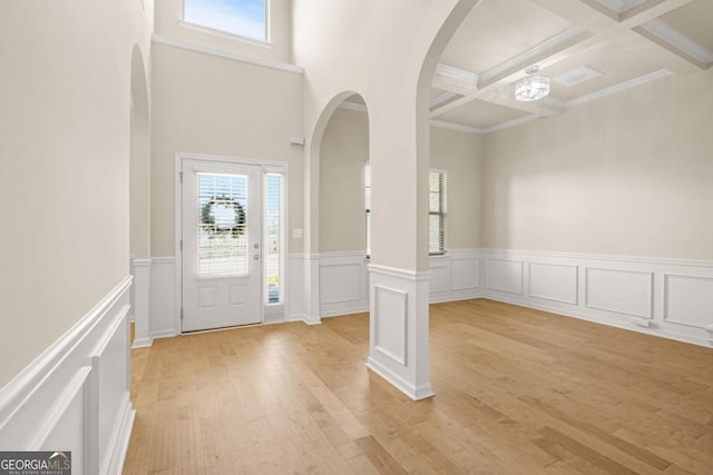 321 Shannon Ct, Mcdonough, GA 30252 - entrance foyer featuring arched walkways, beamed ceiling, light wood-style flooring, a wainscoted wall, and coffered ceiling