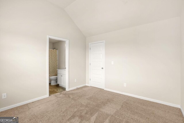 321 Shannon Ct, Mcdonough, GA 30252 - unfurnished bedroom featuring vaulted ceiling, carpet floors, baseboards, and ensuite bath