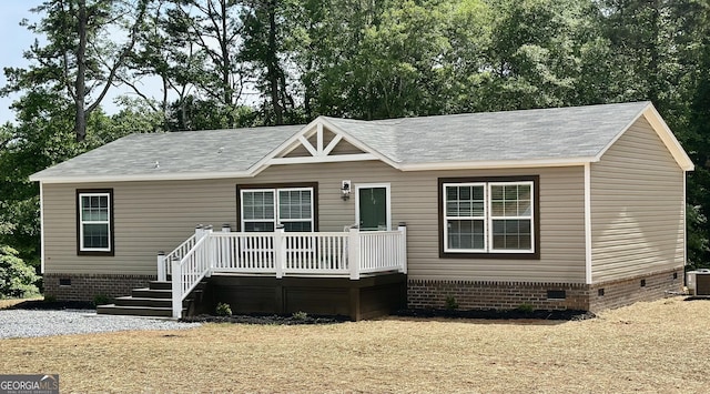 manufactured / mobile home with crawl space, a wooden deck, central AC unit, and a shingled roof