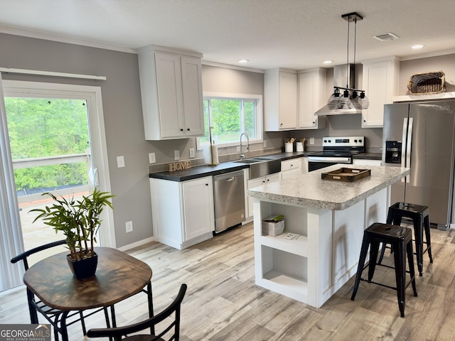 kitchen featuring appliances with stainless steel finishes, wall chimney range hood, a sink, open shelves, and a kitchen breakfast bar