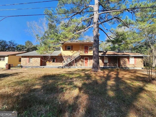 613 Cochran Ave, Albany, GA 31701 - back of property featuring stairs, brick siding, and a lawn