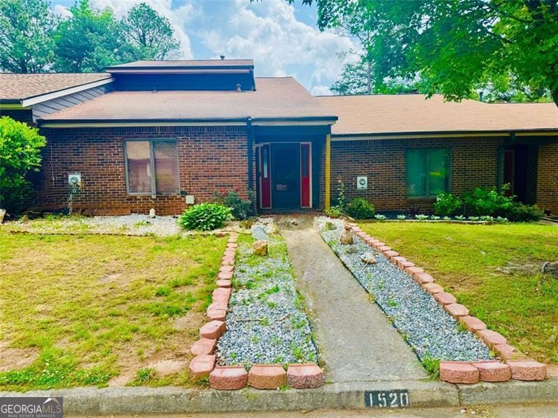 view of front of home with brick siding and a front lawn