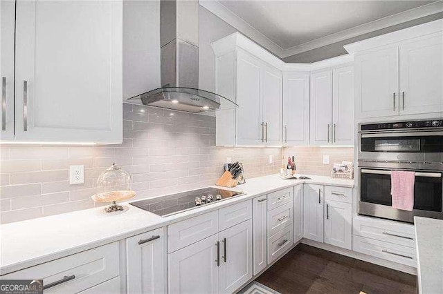1660 Chandler Rd, Lawrenceville, GA 30045 - kitchen featuring wall chimney exhaust hood, stainless steel double oven, white cabinets, ornamental molding, and light countertops