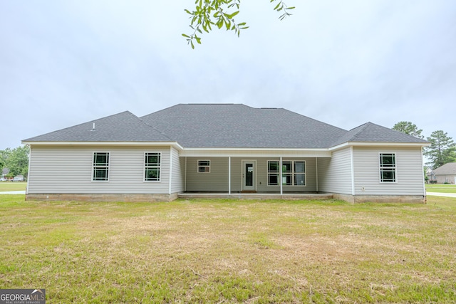 rear view of house featuring a patio area, a yard, and roof with shingles