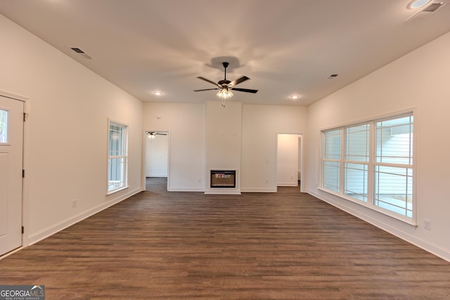 unfurnished living room with dark wood-style flooring, ceiling fan, baseboards, recessed lighting, and a glass covered fireplace