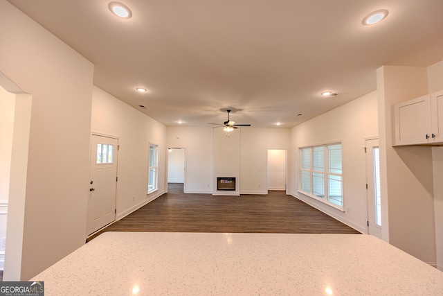 unfurnished living room featuring recessed lighting, dark wood-style flooring, ceiling fan, and baseboards