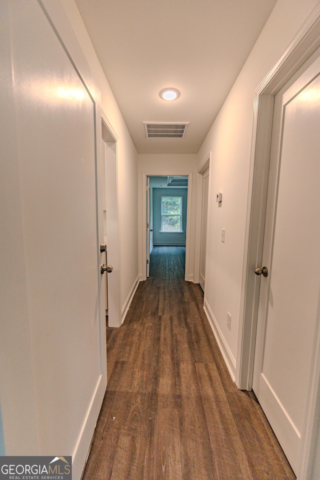 corridor featuring dark wood-style floors and baseboards