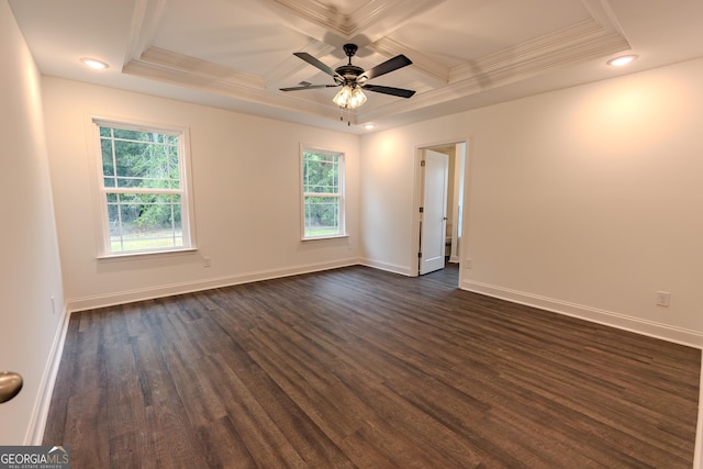 spare room featuring coffered ceiling, plenty of natural light, dark wood-type flooring, baseboards, and ornamental molding