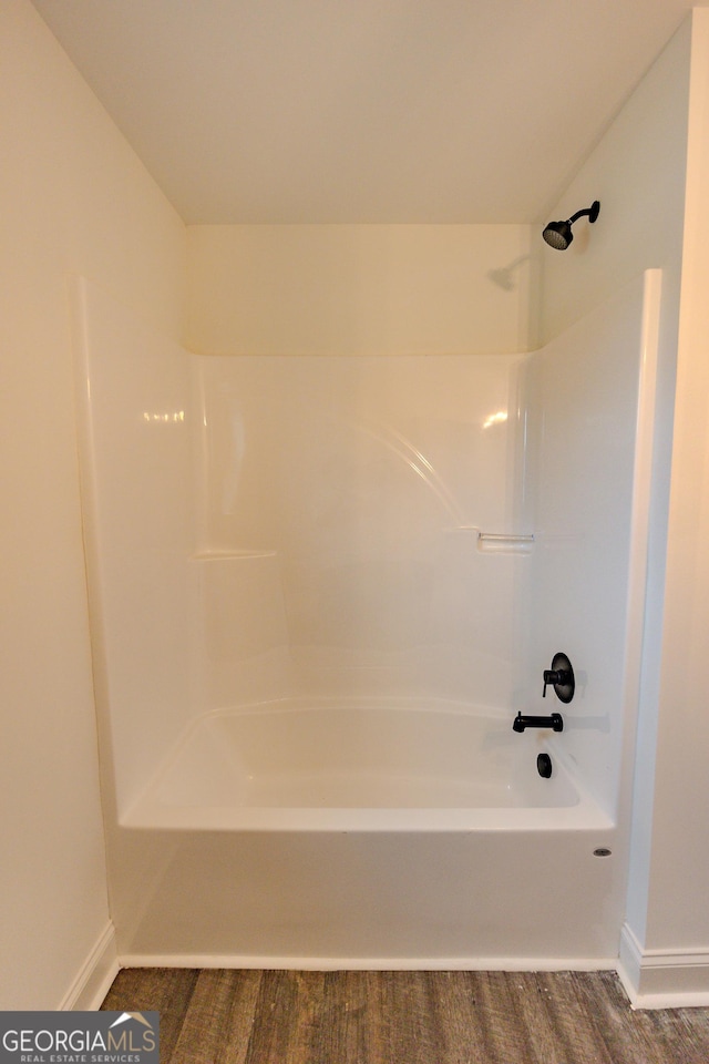 full bathroom with baseboards and washtub / shower combination