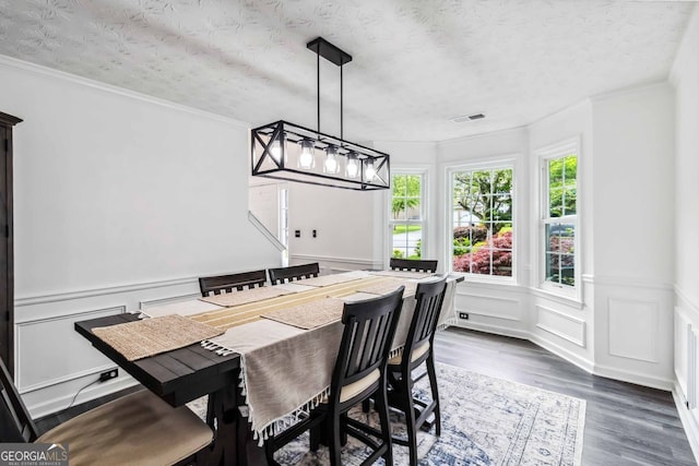870 Underhill Ct, Sugar Hill, GA 30518 - dining space featuring wood finished floors, a decorative wall, a wainscoted wall, a textured ceiling, and ornamental molding