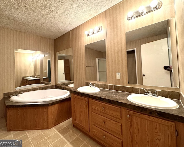 bathroom featuring a textured ceiling, double vanity, tile patterned floors, and a tub