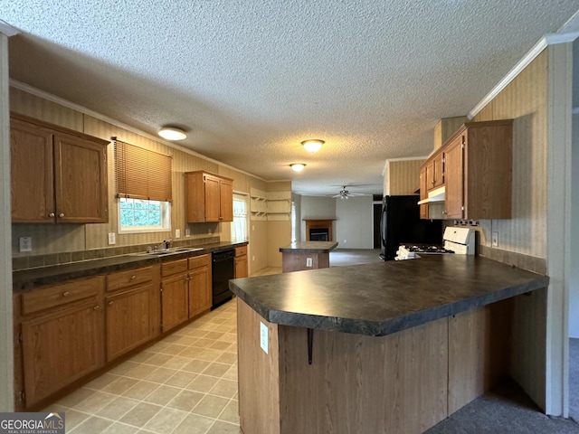 kitchen with black appliances, dark countertops, a peninsula, a textured ceiling, and ornamental molding