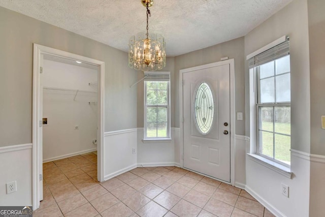 2355 Glen Chase Ln, Lawrenceville, GA 30044 - entrance foyer featuring a chandelier, light tile patterned floors, a textured ceiling, and baseboards