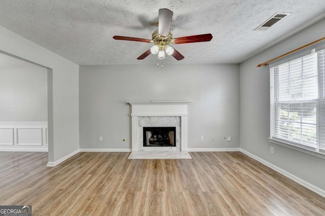 2355 Glen Chase Ln, Lawrenceville, GA 30044 - unfurnished living room with a textured ceiling, ceiling fan, wood finished floors, and a high end fireplace