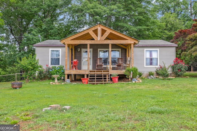 view of front facade featuring a front lawn, covered porch, and view of scattered trees