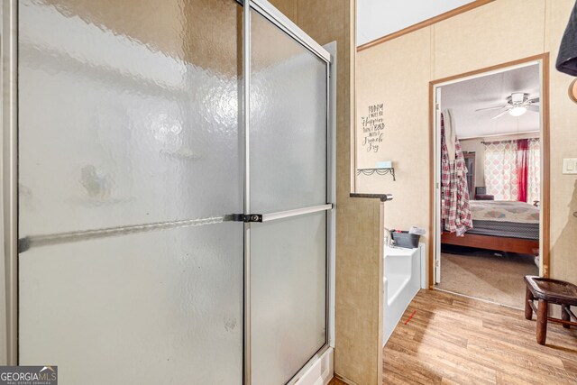 full bathroom featuring ensuite bath, wood finished floors, a shower stall, ceiling fan, and a garden tub