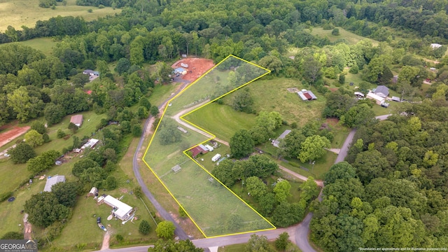 aerial view of property's location featuring property parcel outlined and a heavily wooded area