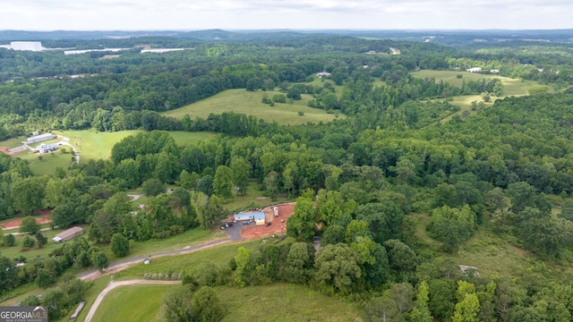 aerial view of property and surrounding area featuring a heavily wooded area