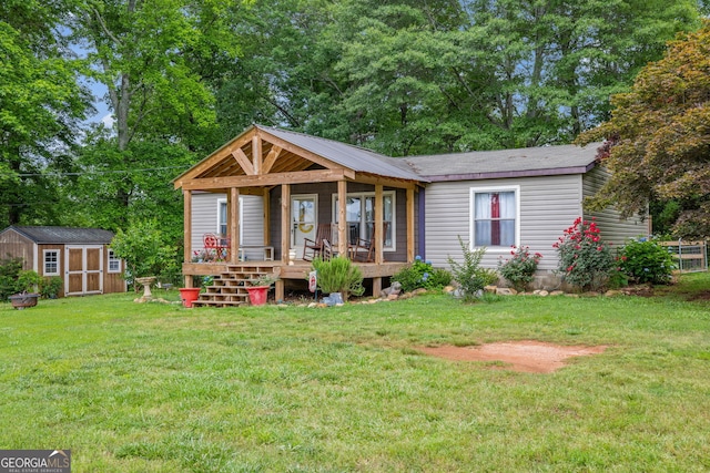 view of front facade with a porch, a storage unit, a front yard, and an outbuilding