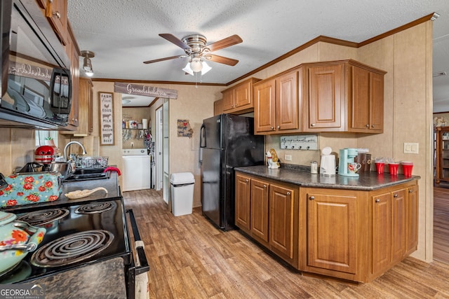 kitchen with black appliances, washer / clothes dryer, a sink, a ceiling fan, and ornamental molding