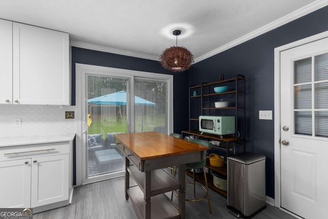 dining space featuring wood finished floors and ornamental molding