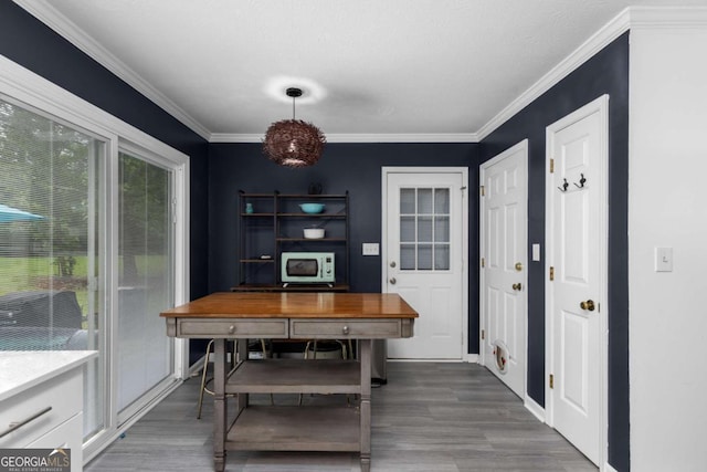 dining area featuring wood finished floors and ornamental molding