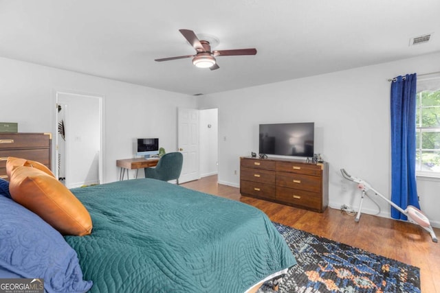 bedroom with wood finished floors, baseboards, and ceiling fan