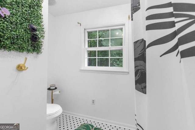 bathroom featuring toilet and baseboards