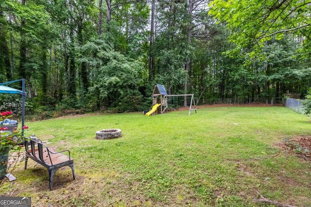 view of yard with a playground and an outdoor fire pit