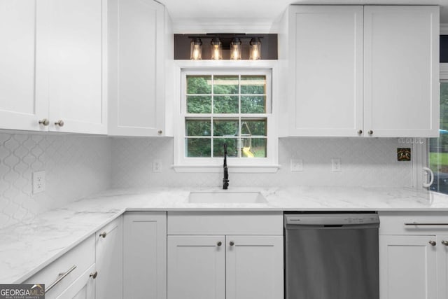 kitchen featuring stainless steel dishwasher, a sink, white cabinets, and decorative backsplash