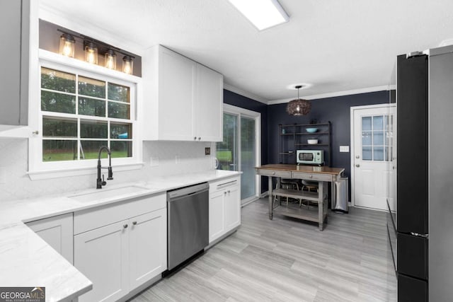 kitchen with dishwasher, freestanding refrigerator, a sink, white cabinets, and crown molding
