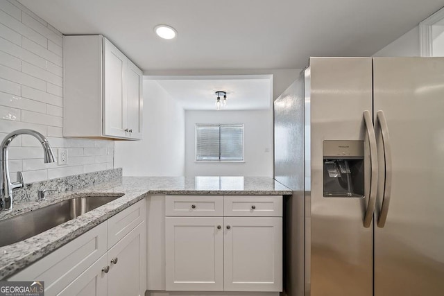 510 Northridge Crossing Dr, Sandy Springs, GA 30350 - kitchen featuring stainless steel fridge with ice dispenser, a sink, white cabinetry, decorative backsplash, and light stone counters