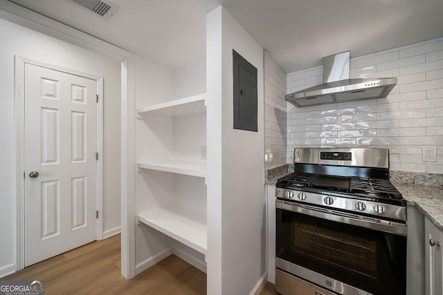 510 Northridge Crossing Dr, Sandy Springs, GA 30350 - kitchen with stainless steel gas range, wall chimney range hood, electric panel, tasteful backsplash, and light wood-style floors