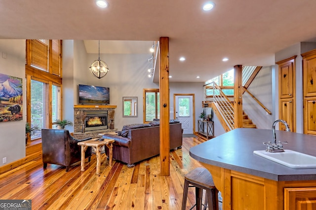 living area featuring light wood-style floors, stairs, recessed lighting, and a fireplace