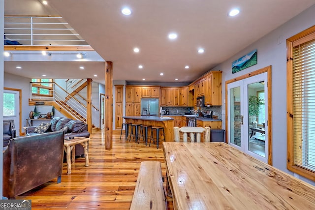 dining room featuring light wood-type flooring, stairway, and recessed lighting